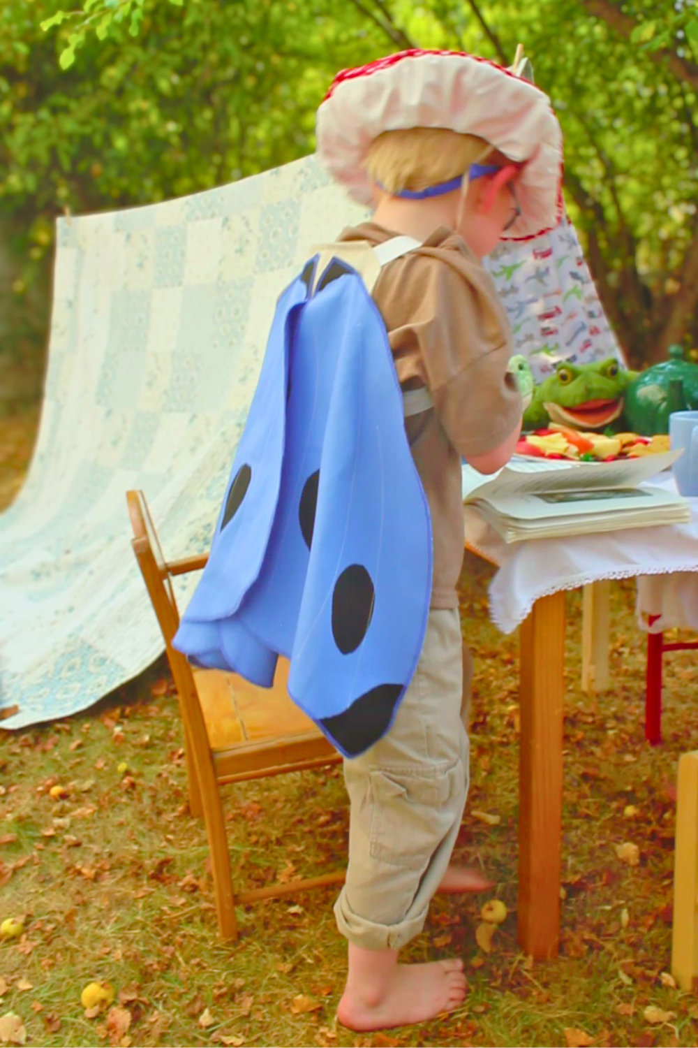 Child in costume with a table and tent in an outdoor setting
