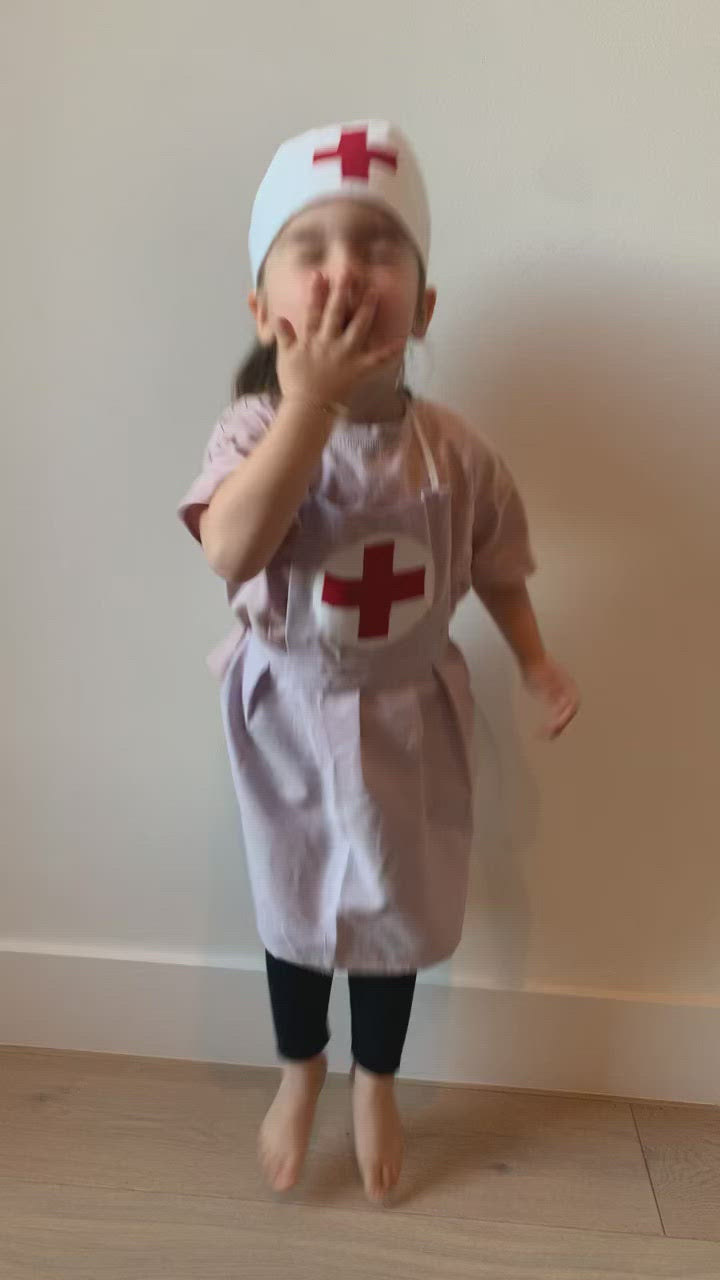 Girl jumping for joy wearing nurse apron costume