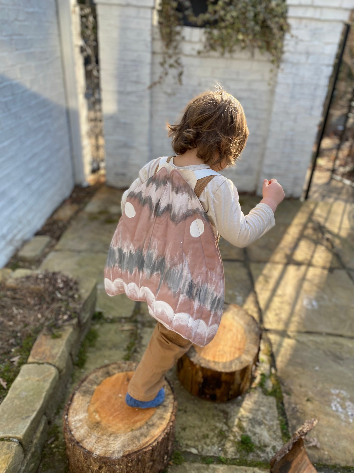 Child in gypsy moth costume playing pretend in nature.